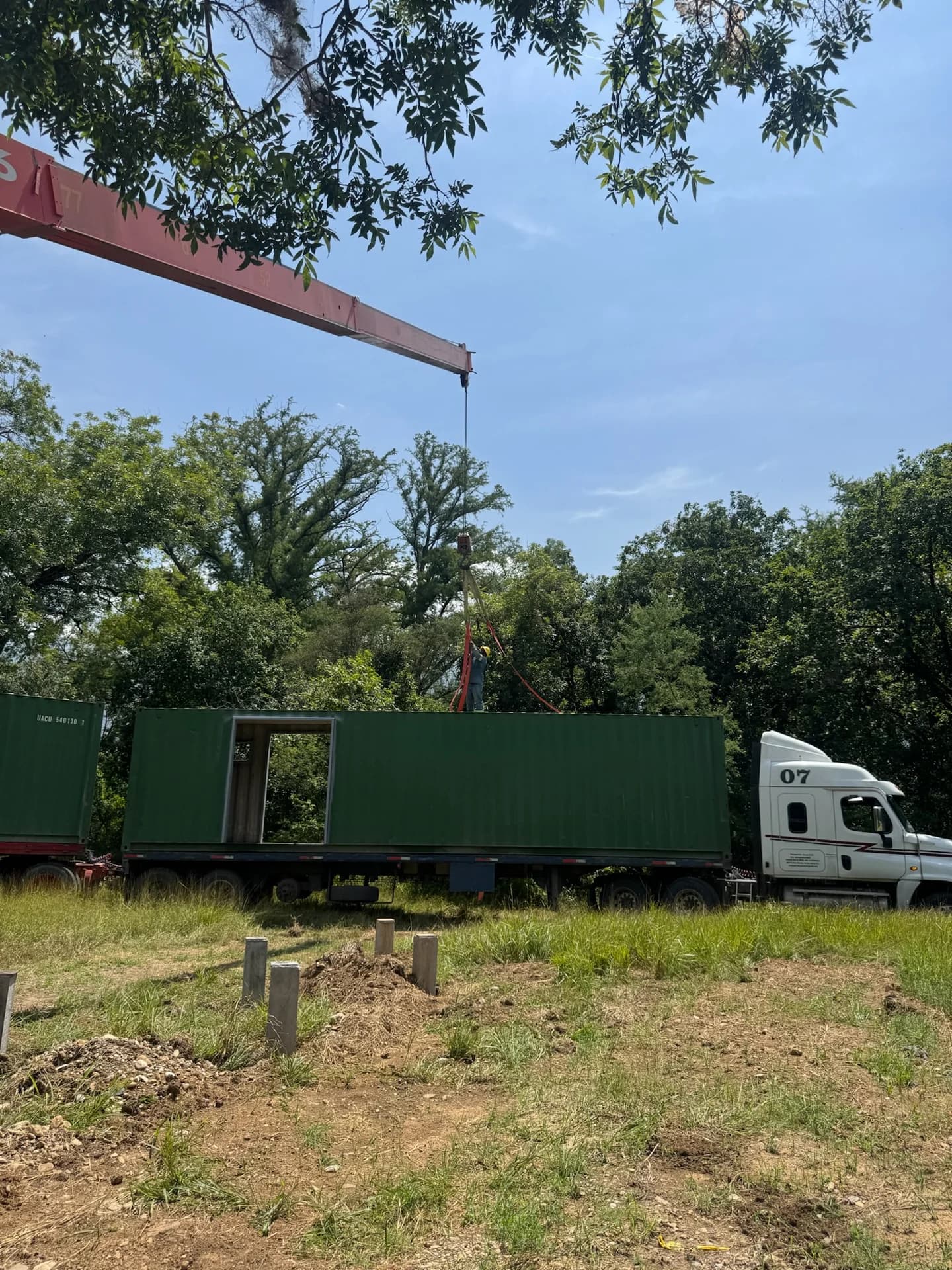 Grúa instalando módulo contenedor sobre cimientos de concreto